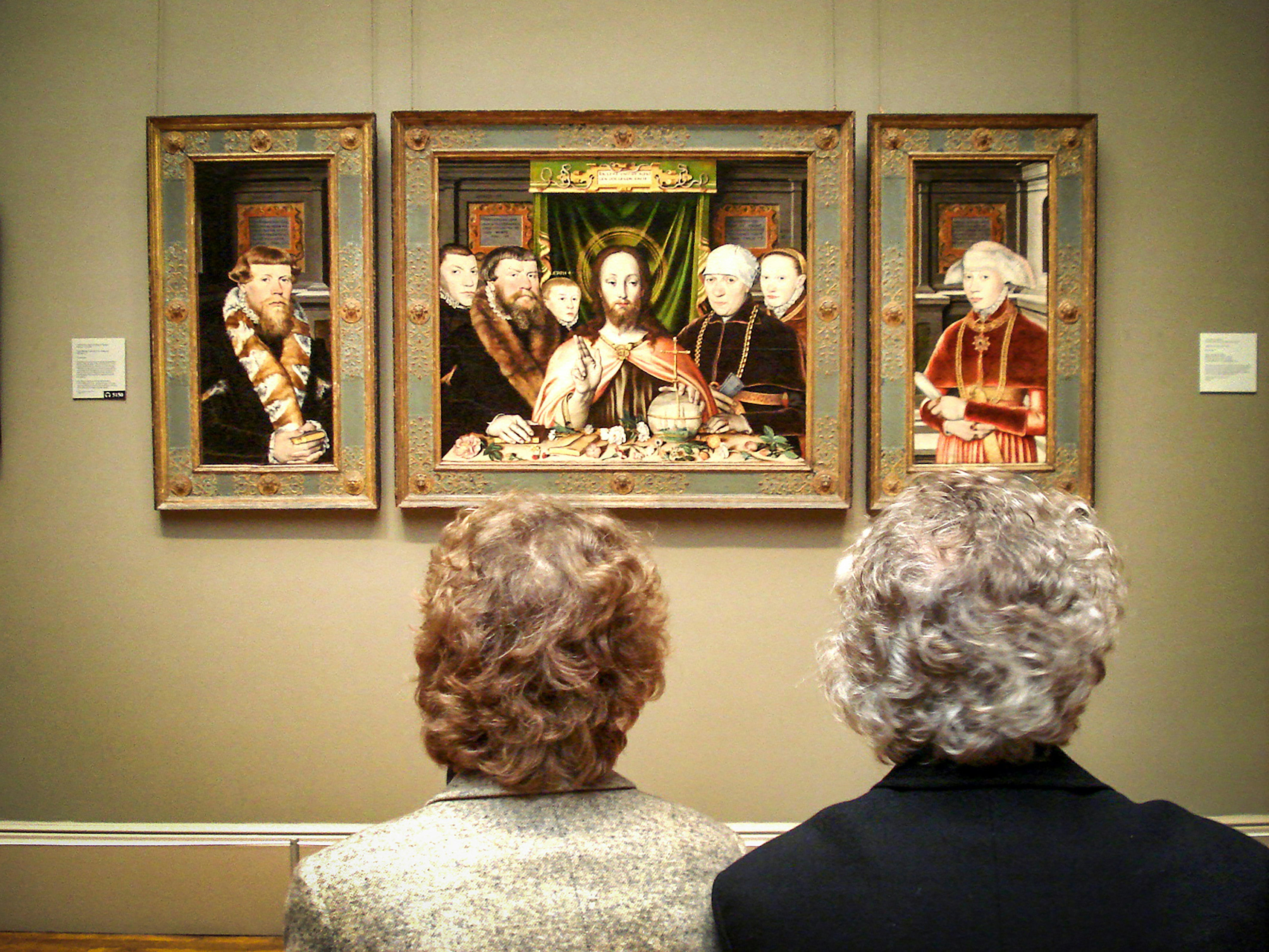 people in black suit jacket standing in front of brown wooden framed wall art